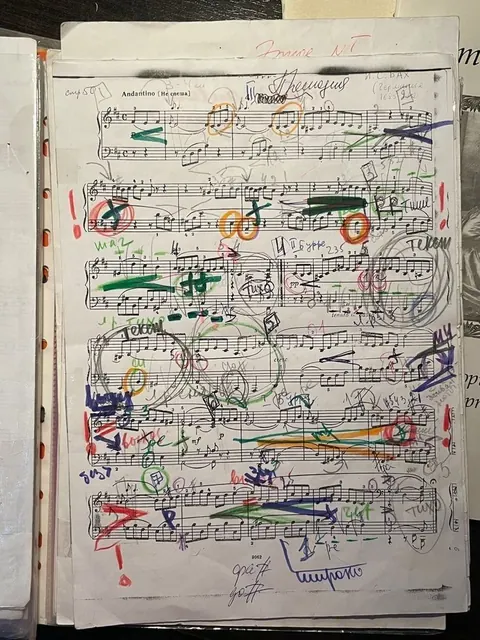Page of sheet music covered in colourful handwritten annotations, circles and arrows.