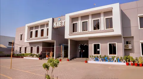 KIET building in daylight with SPORTS GALA letters and potted plants in the courtyard.