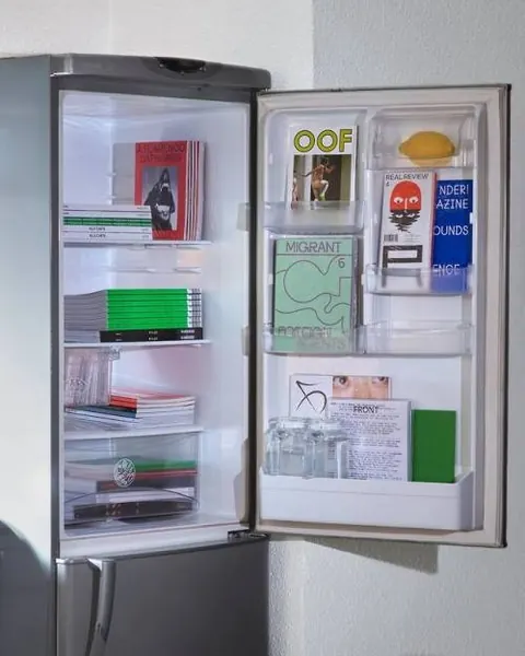 Open refrigerator stocked with independent magazines and zines instead of food.