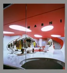 Retail interior with a glossy red ceiling, round lights and a chrome display.